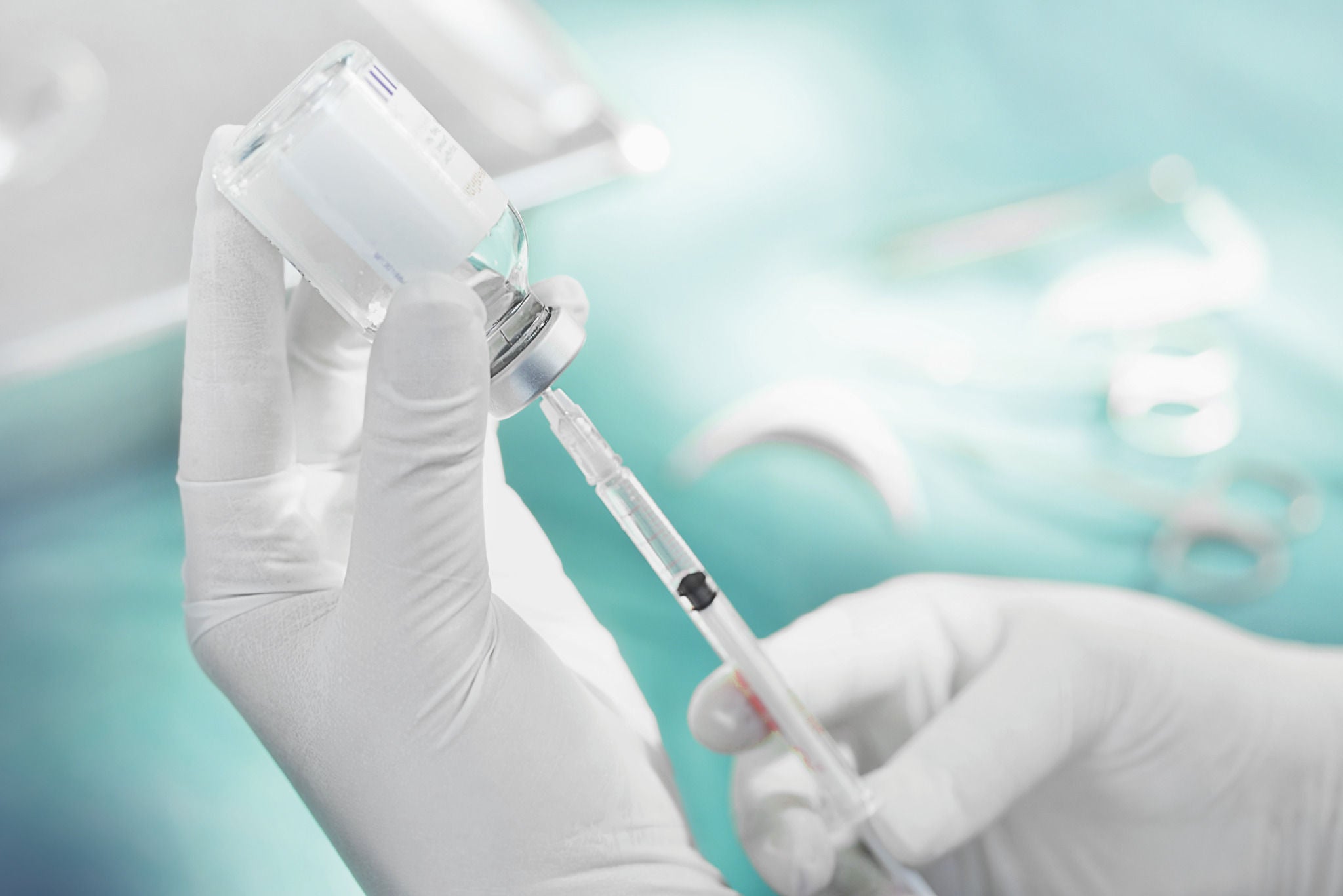 Hand holding syringe and medicine vial prepare for injection with surgical equipment and medicine vial background.; Shutterstock ID 575241253; purchase_order: -; job: -; client: -; other: -